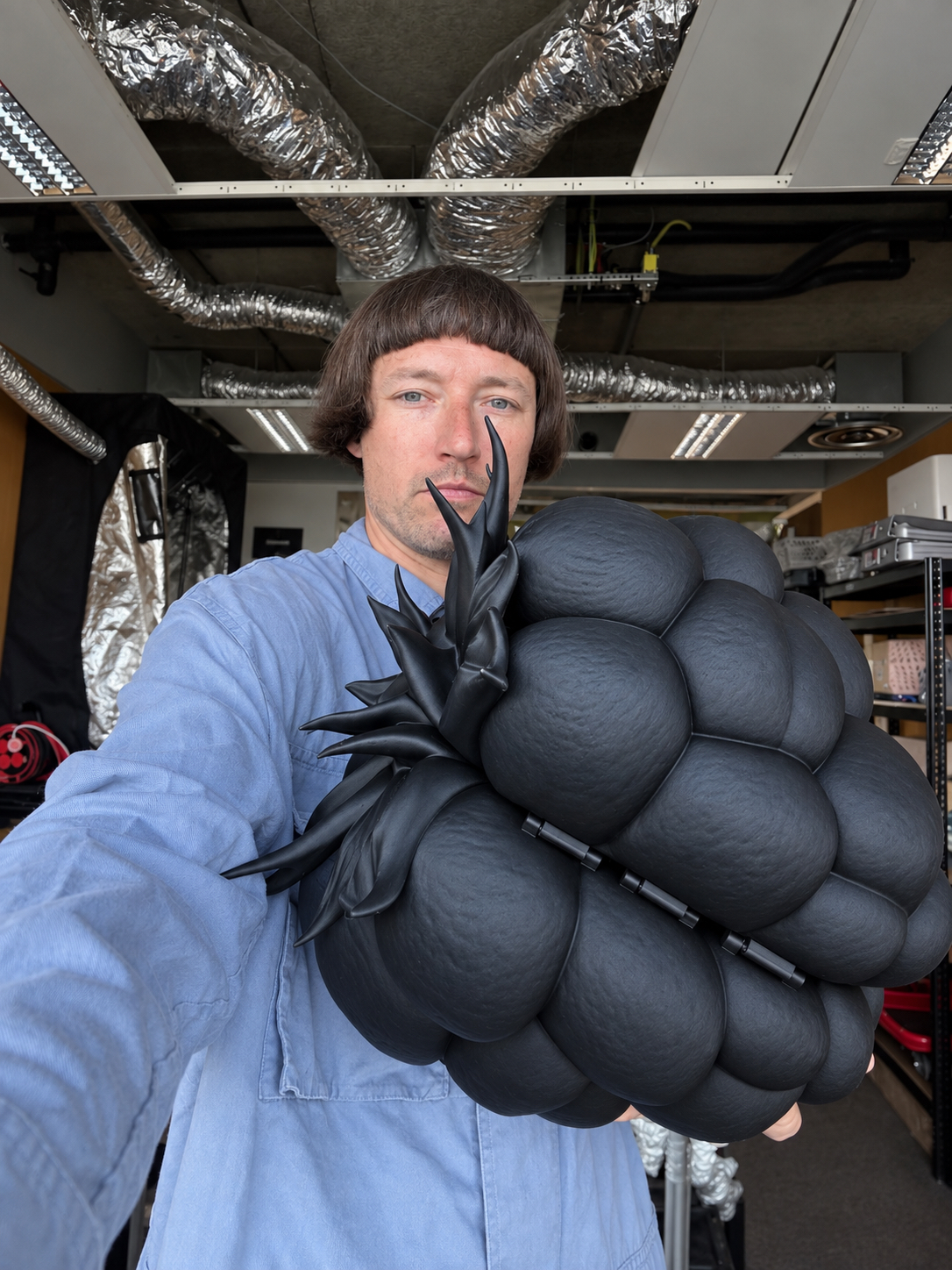The artist holding the closed raspberry sculpture