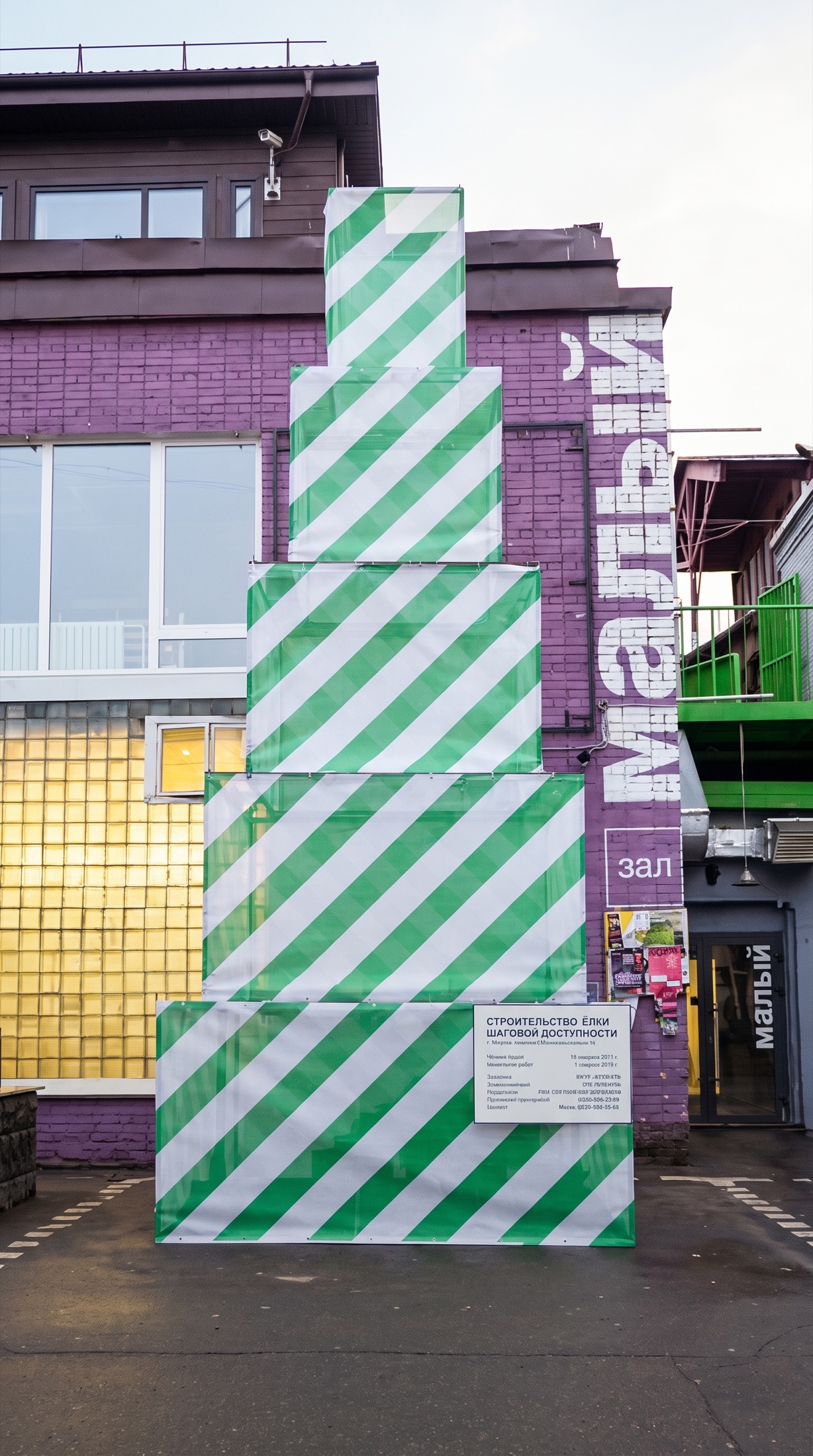 Frontal day view of Christmas Tree Under Construction with green and white striped construction wrapping