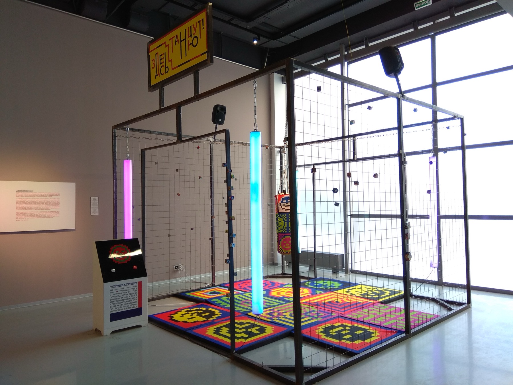 General view of Ici on danse installation with steel frame, LED lighting, punching bag, and patterned floor