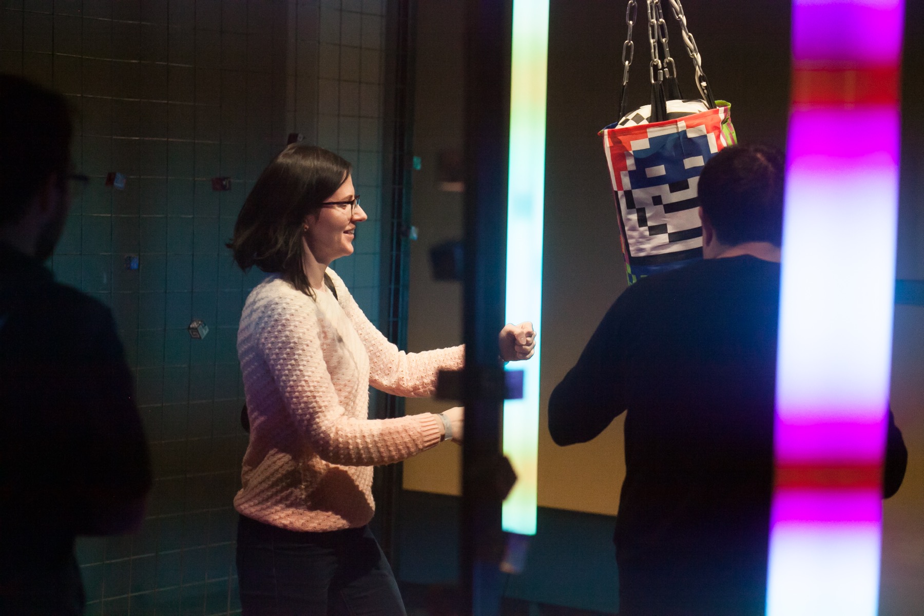 Visitors engaging with the punching bag and light elements in Ici on danse