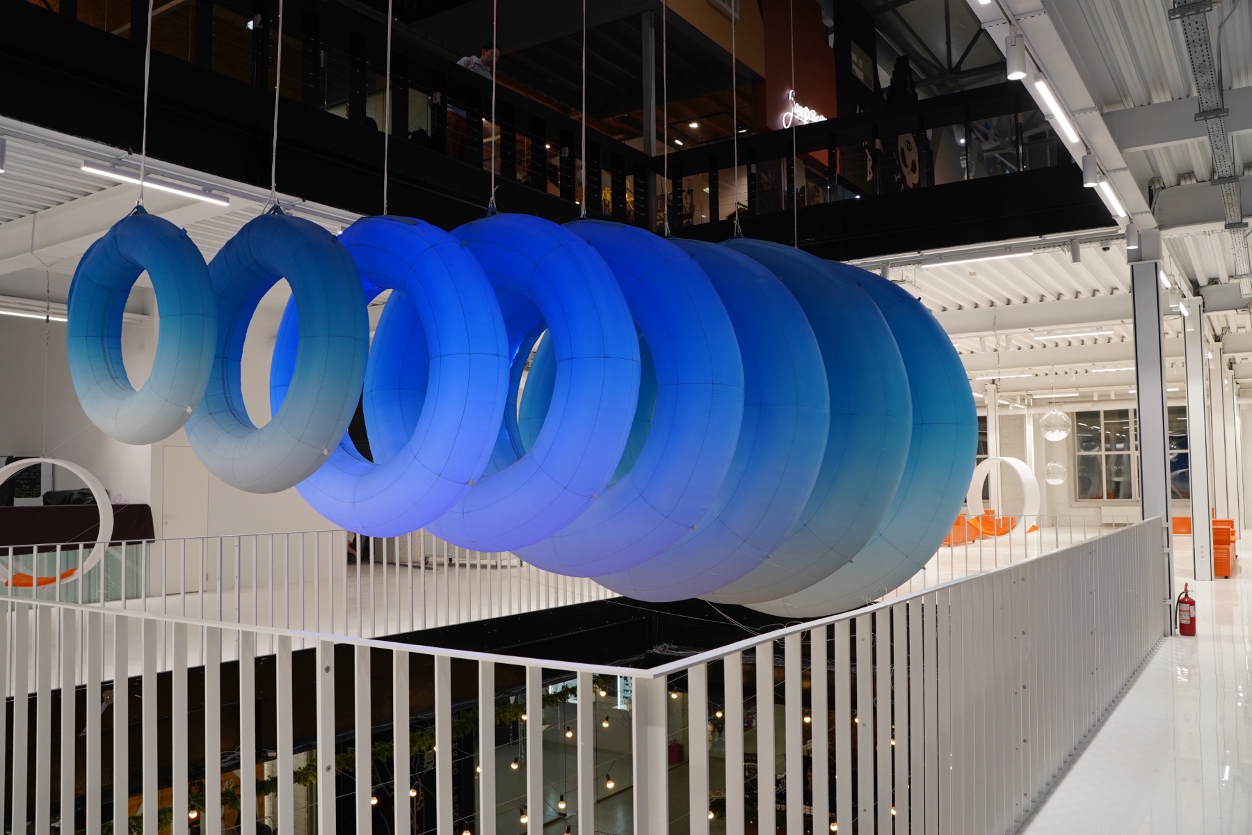 1=0 blue inflatable rings suspended above a railing with internal lighting