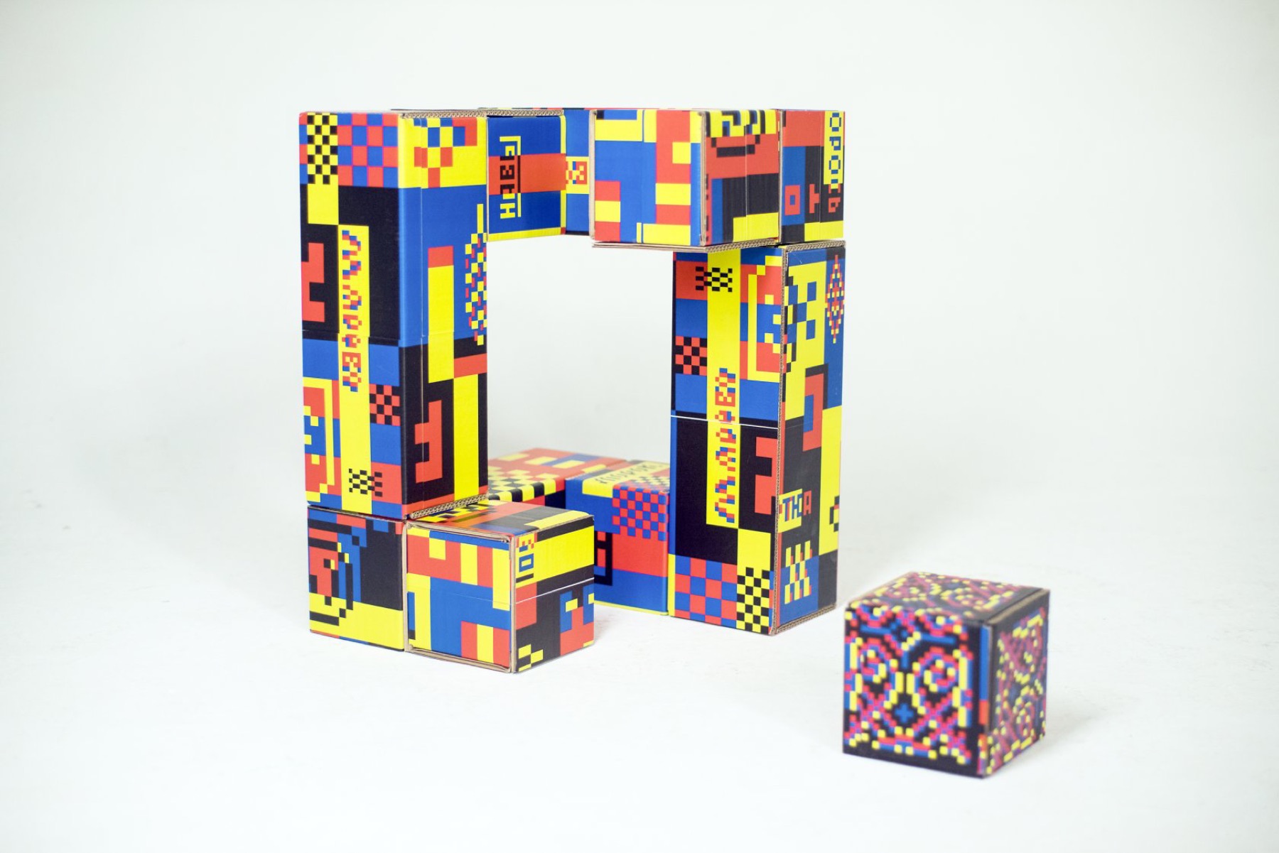 Pangan Tetris cardboard modules arranged as a low arch with a separate cube nearby