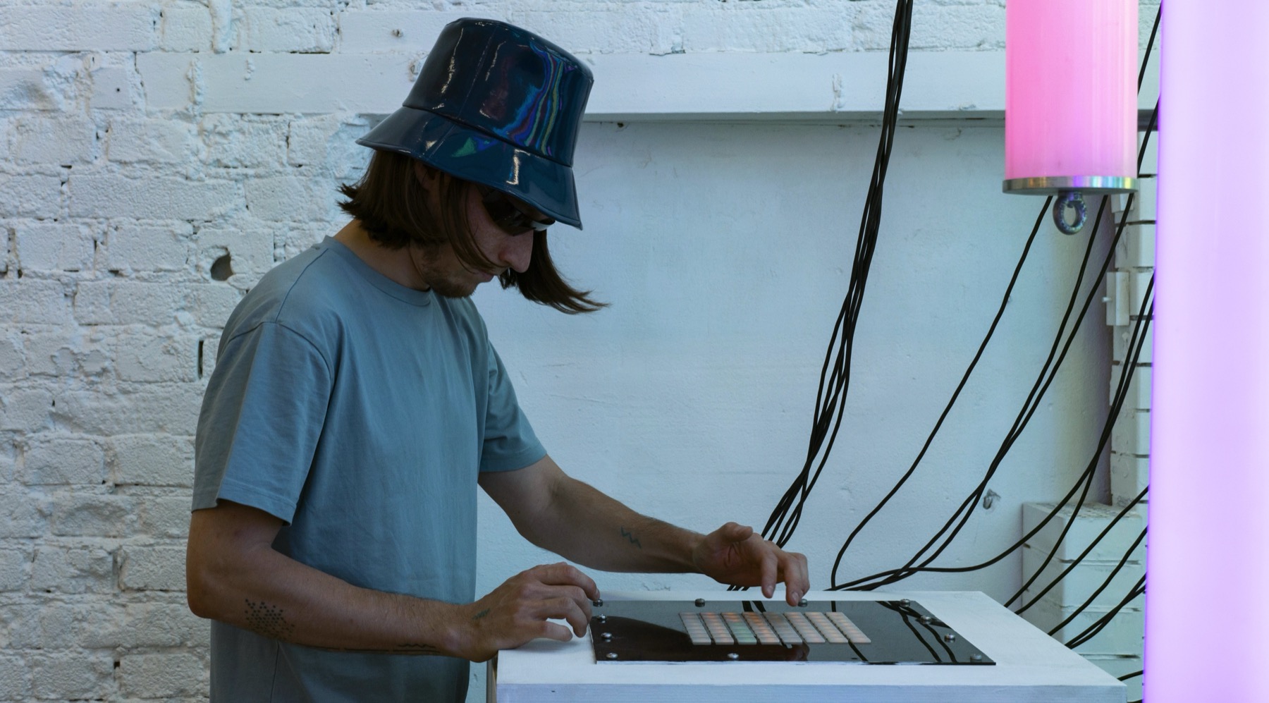 Visitor interacting with the POKE-N-CLICK control surface beside illuminated lamps