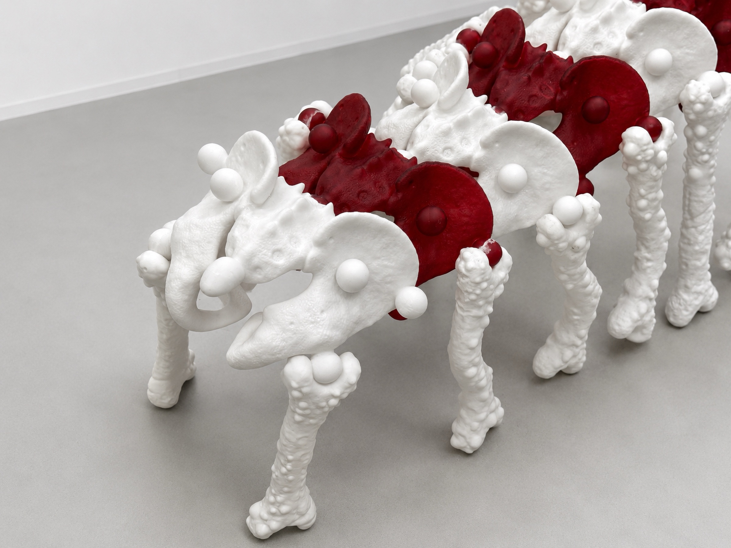 Close view of alternating red and white modules and bone-like legs
