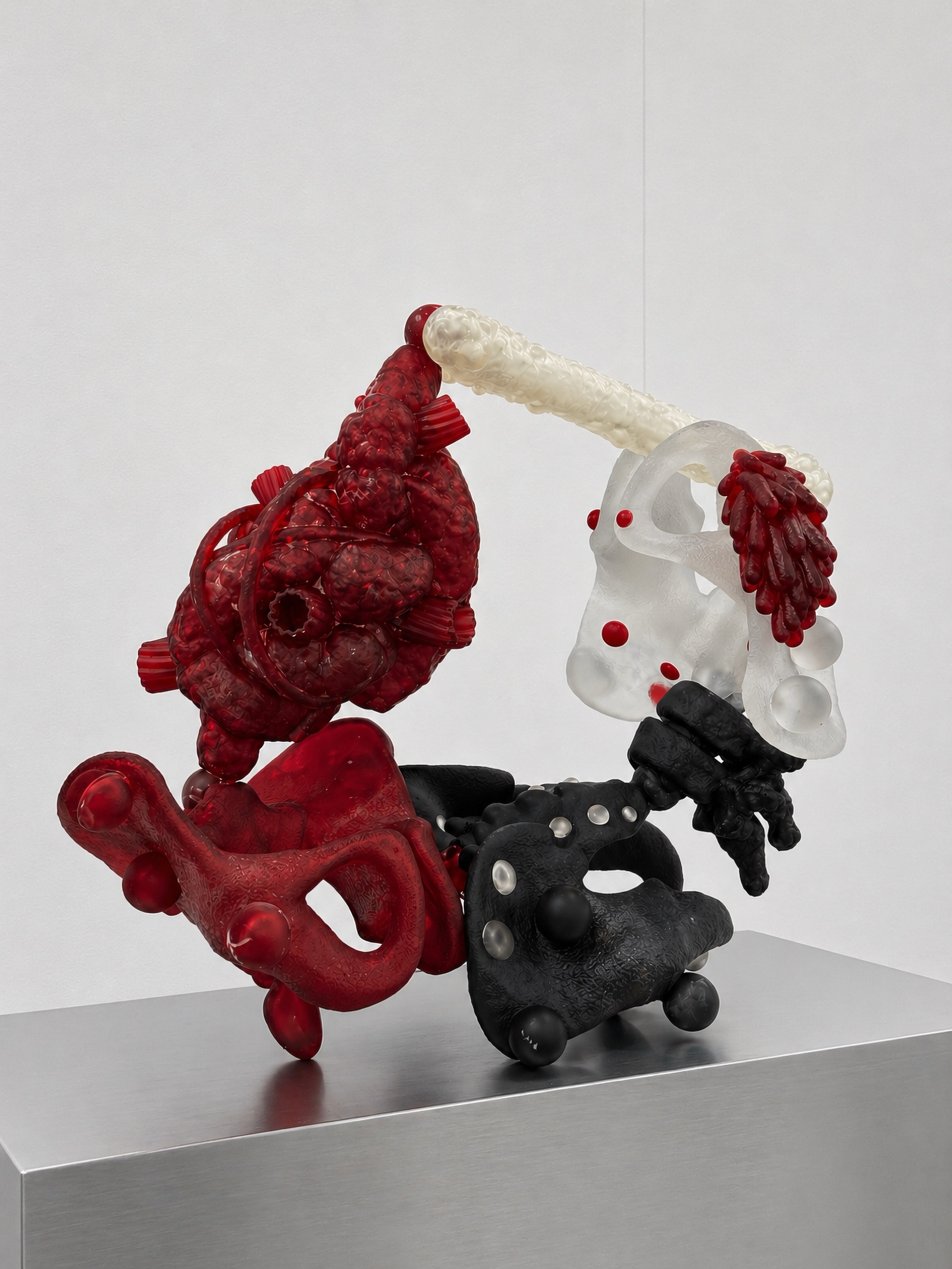 Red, black, and translucent Rebone organizm'os organism assembled on a metal plinth