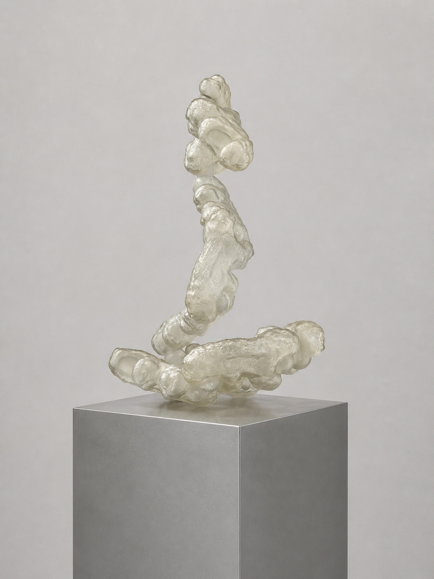 Translucent white Rebone organizm'os organism balanced on a metal pedestal