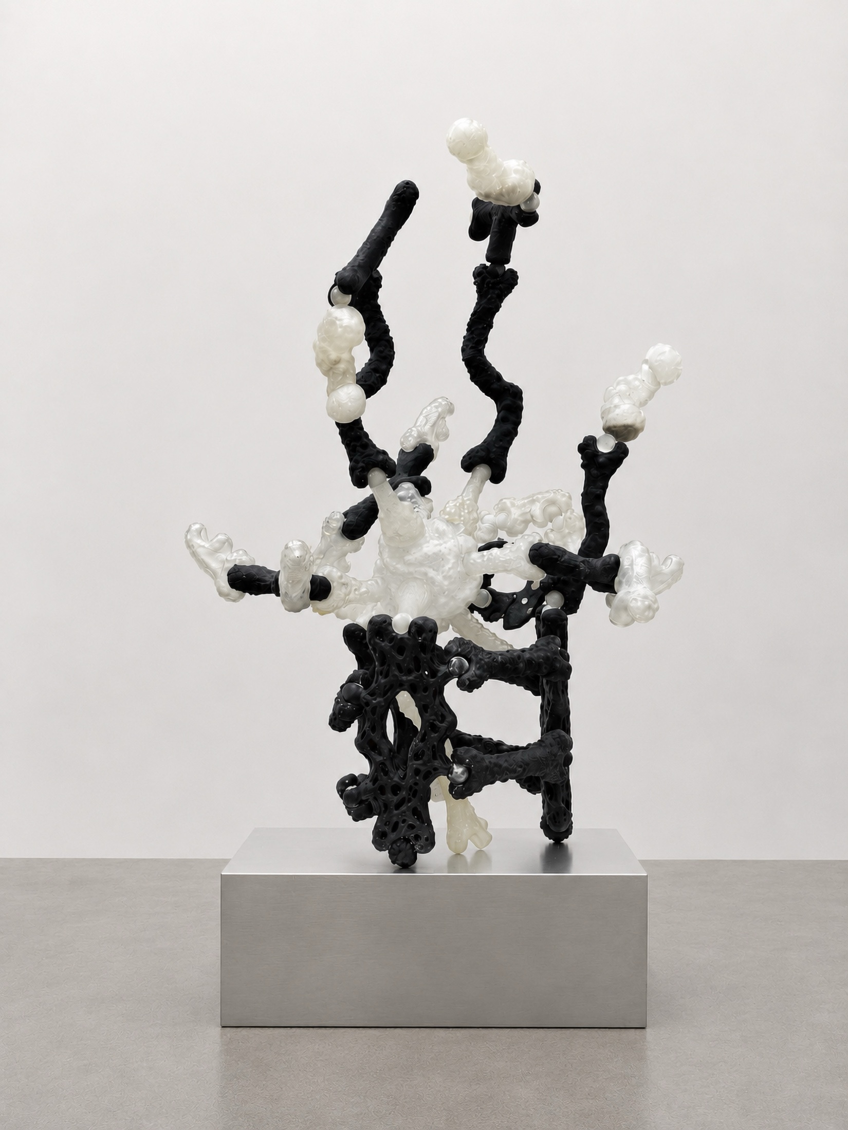 Black and white Rebone organizm'os assembled figure on a metal pedestal