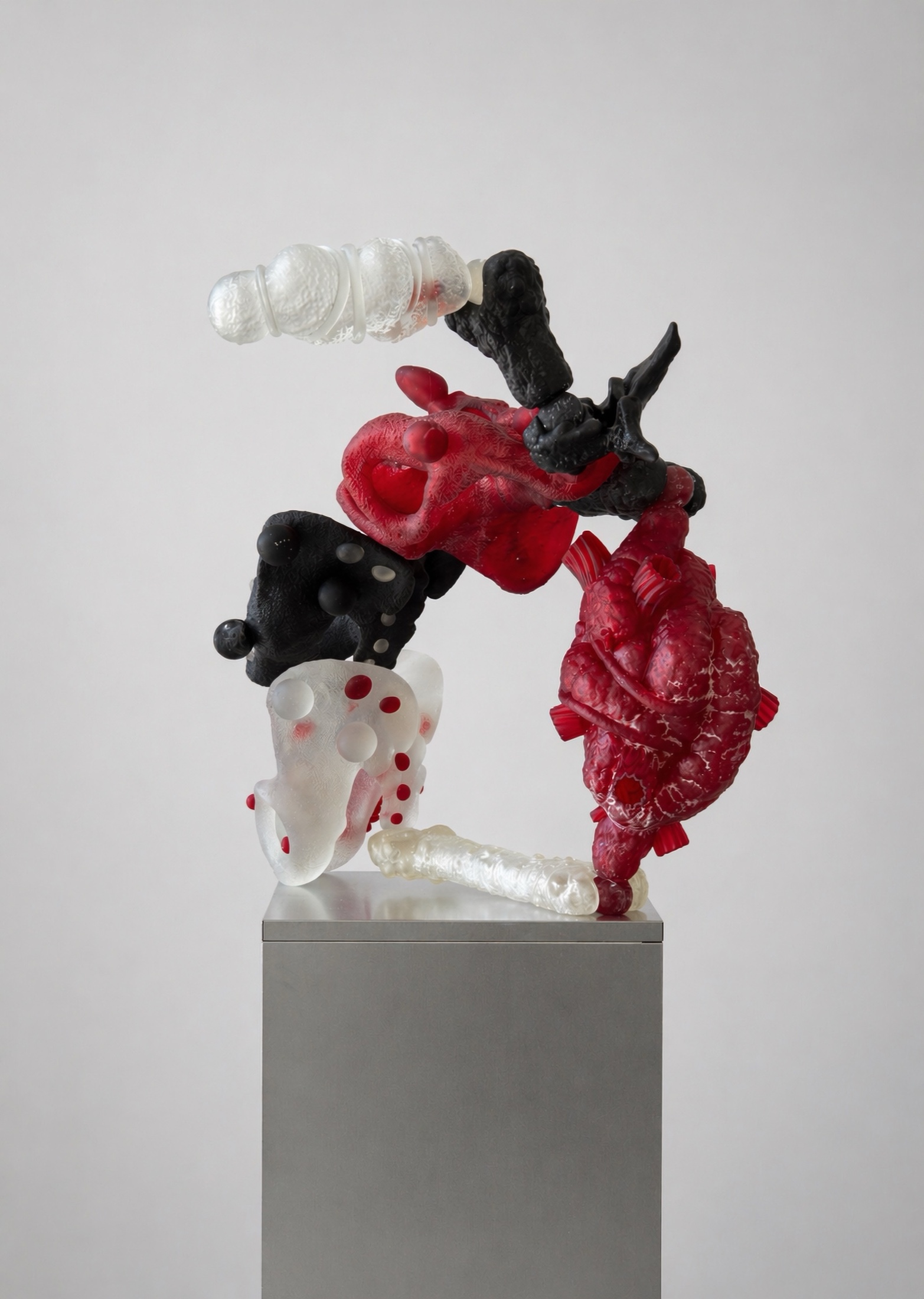 Red, black, and translucent Rebone organizm’os organism on a metal plinth