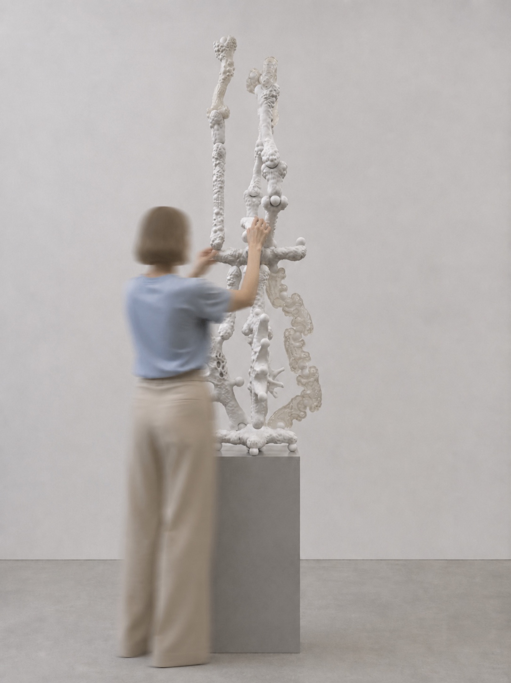 Visitor assembling a tall white Rebone organizm’os structure