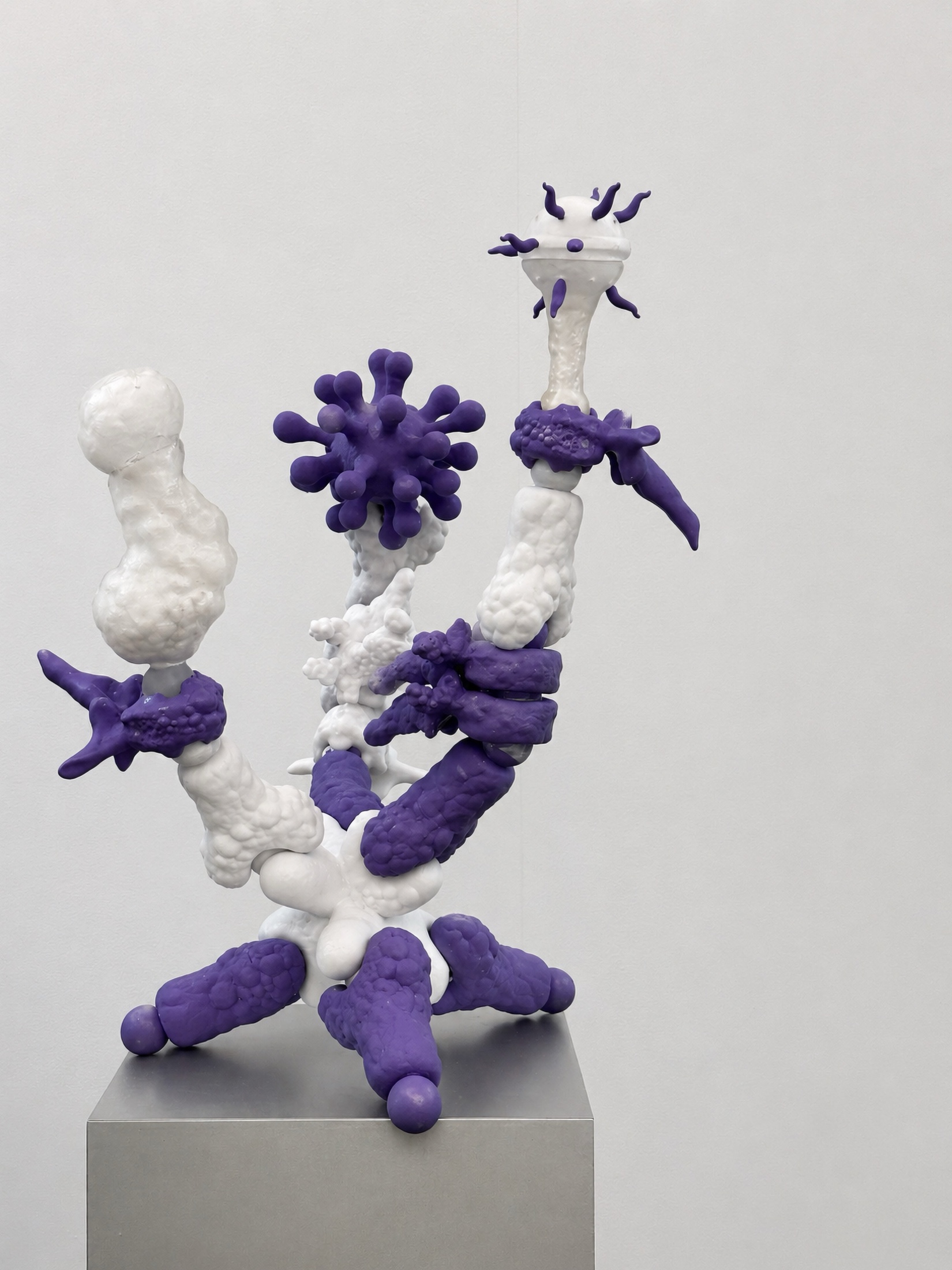 White and purple Rebone organizm’os structure rising from a metal plinth