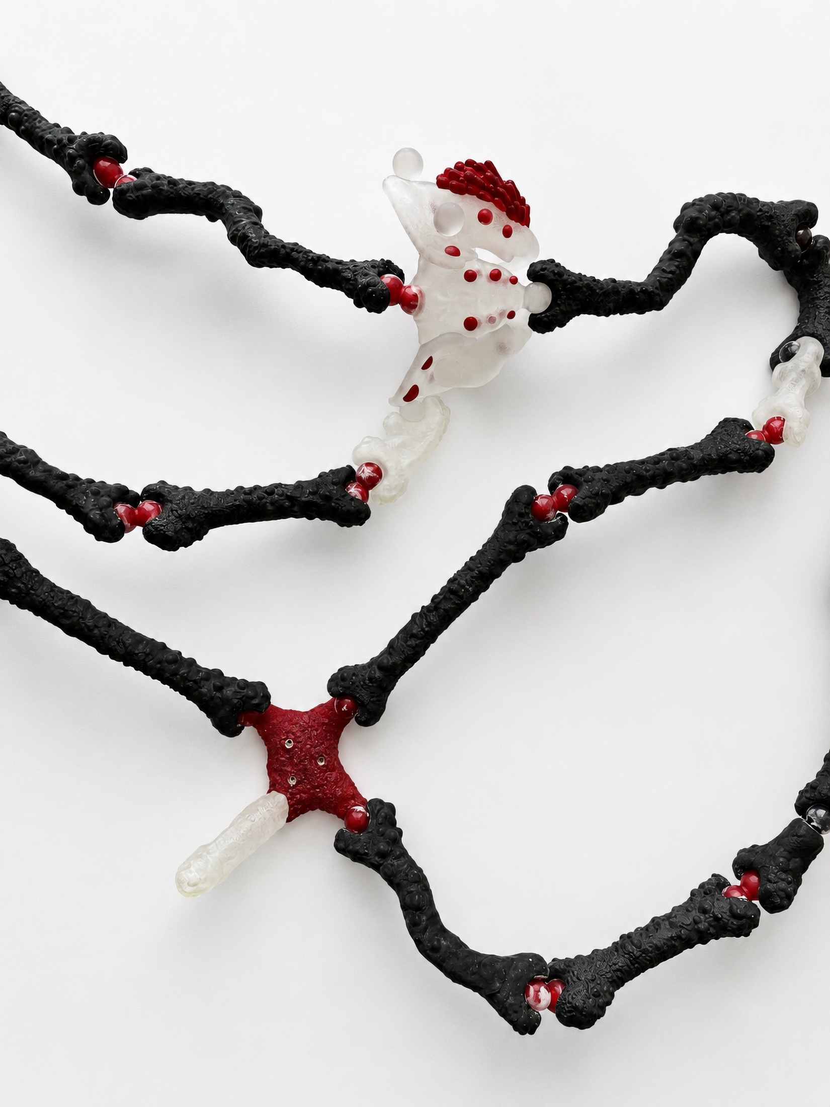 Black Rebone organizm’os structure with red and translucent elements seen from above