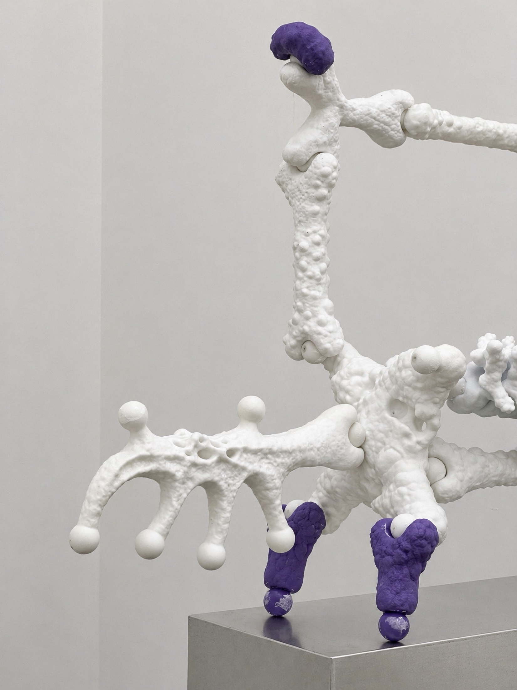 White Rebone organizm’os structure with purple details on a metal plinth