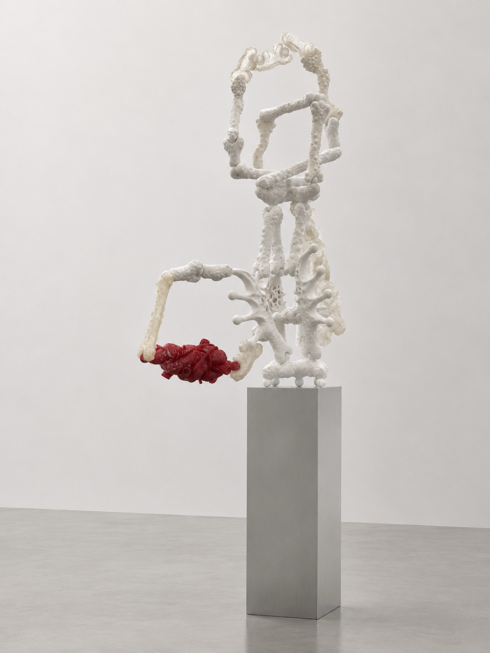 White Rebone organizm’os structure with red organ element on a tall metal plinth
