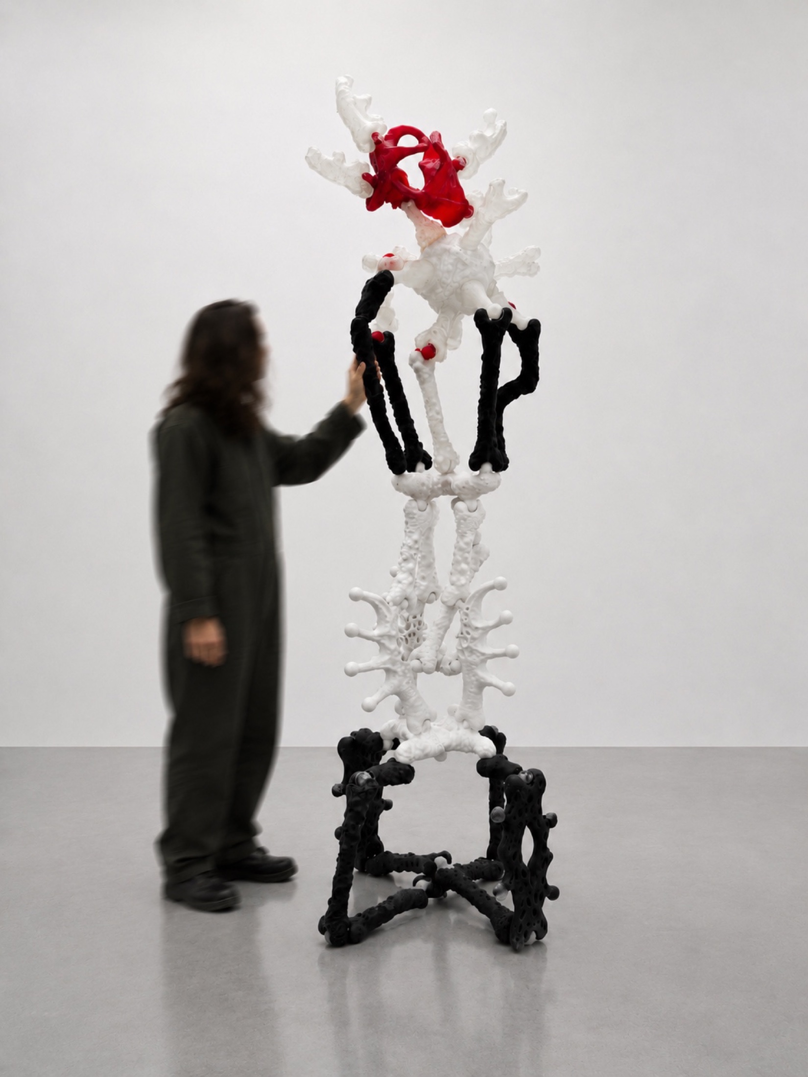 Tall Rebone organizm’os structure with a visitor standing beside it