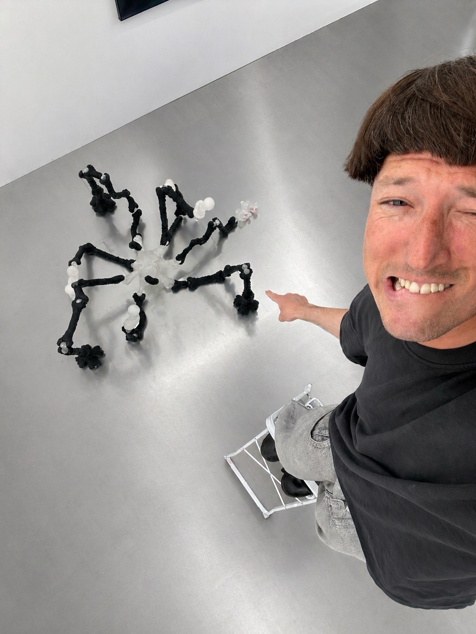Artist selfie beside a black and translucent Rebone organizm’os floor structure