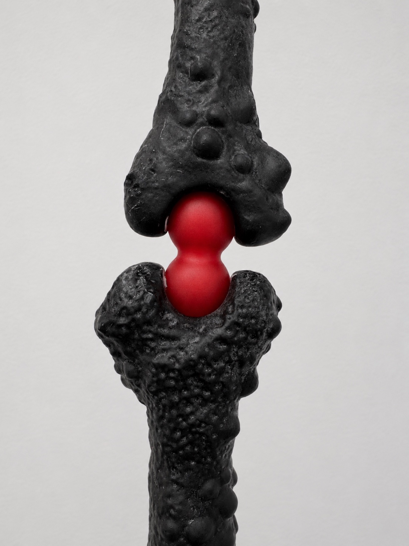 Close view of a black Rebone organizm'os joint with a red spherical connector