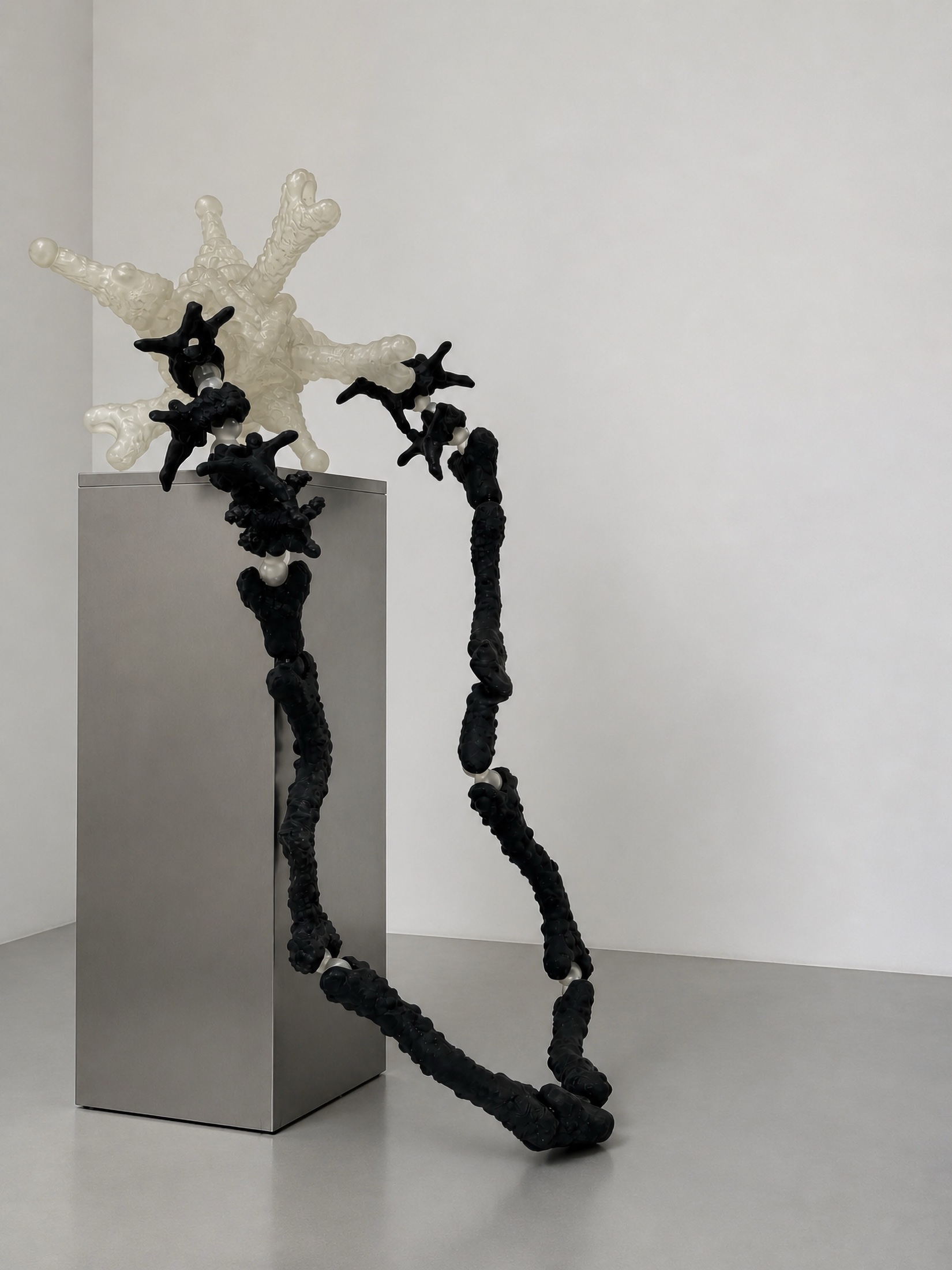 Black Rebone organizm'os structure leaning from a metal pedestal