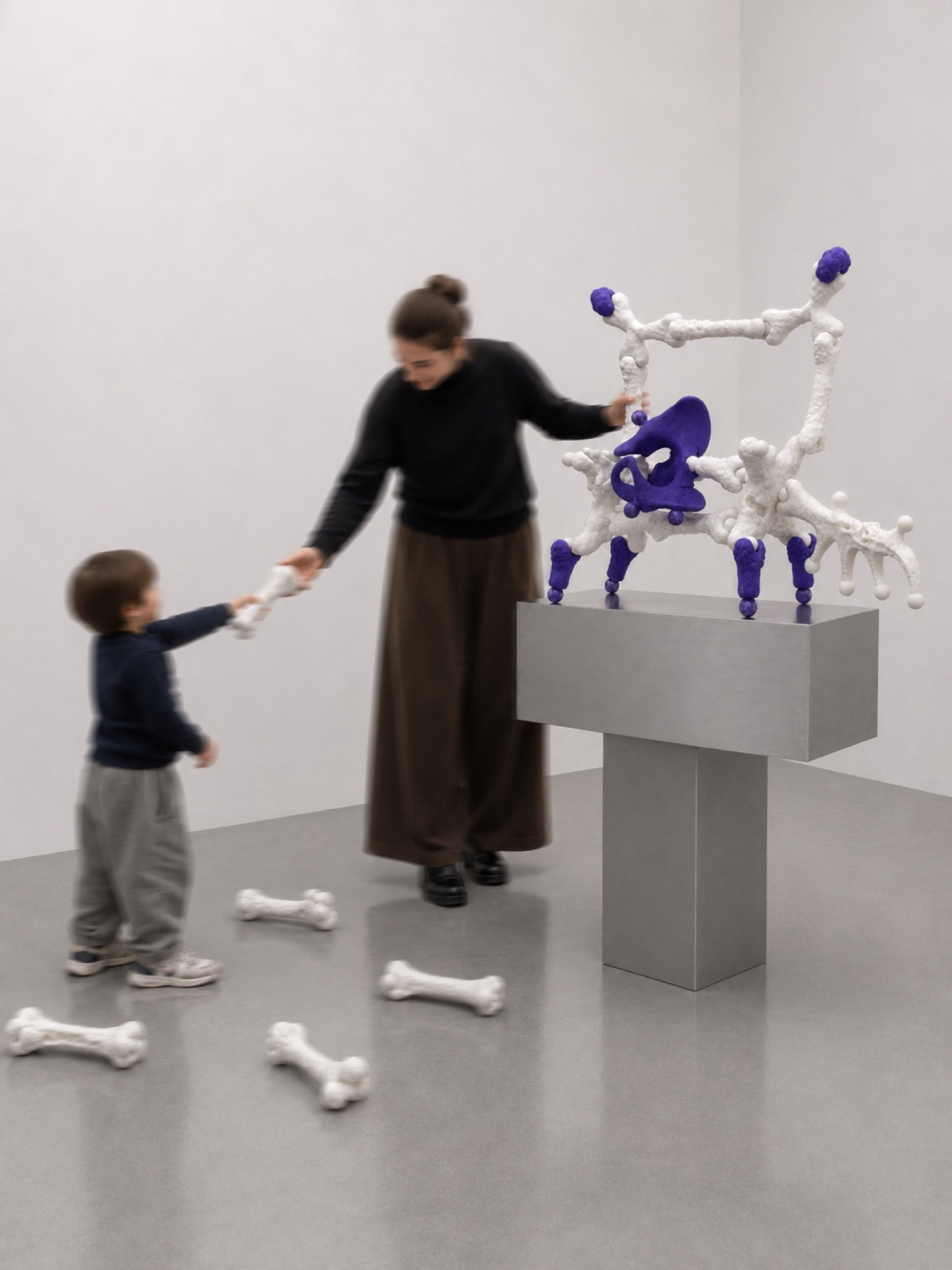 Adult and child assembling a white and purple Rebone organizm'os structure in a gallery