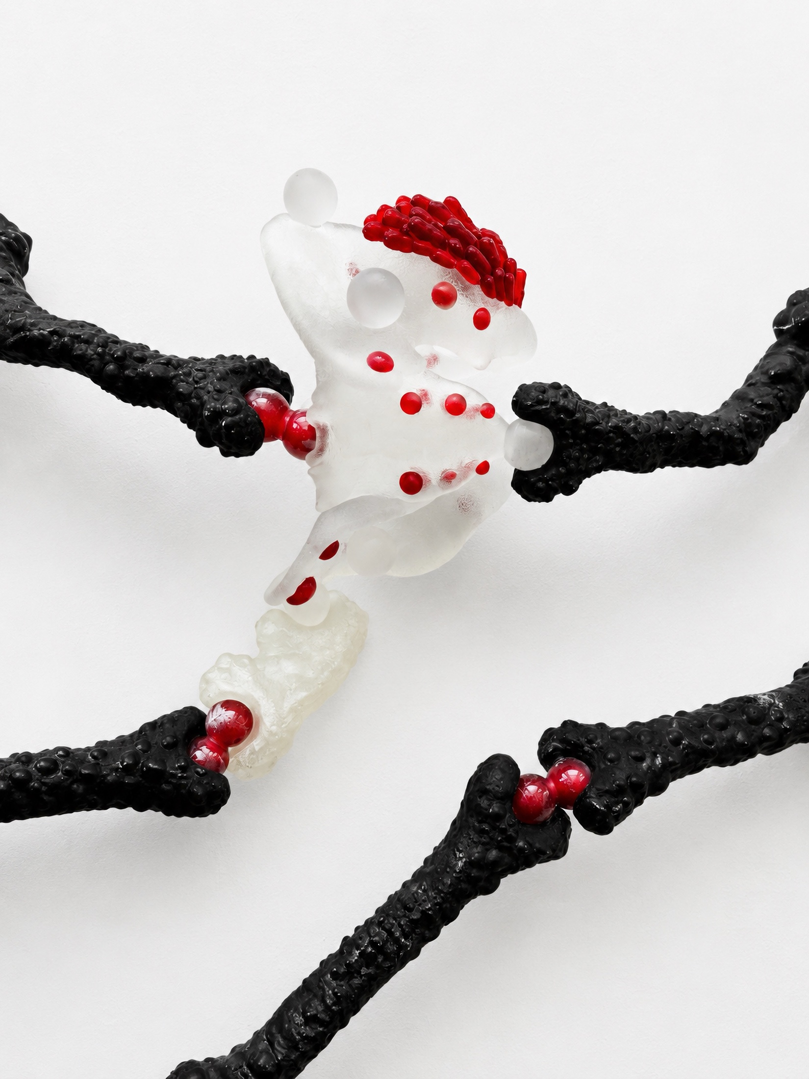 Close view of a translucent Rebone organizm'os organ with red details and black bone-like arms