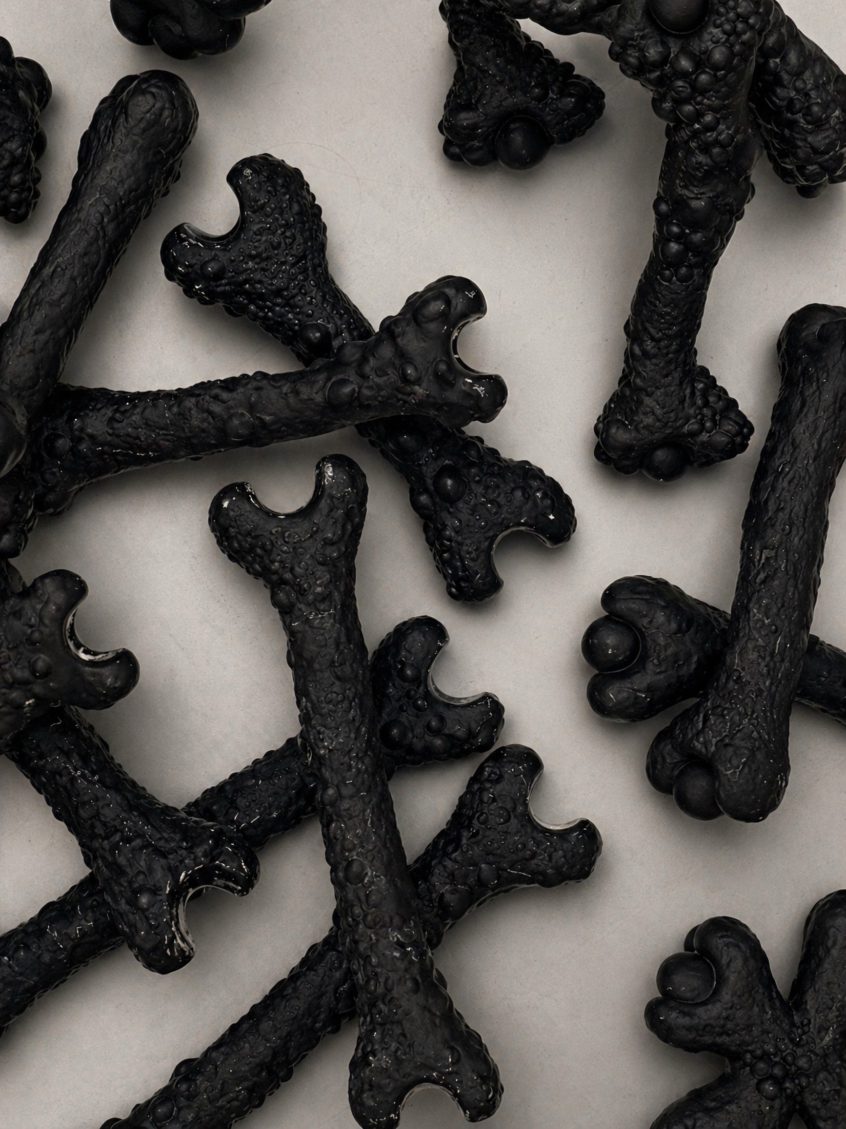 Close view of glossy black Rebone organizm'os bone-like components on a metal surface