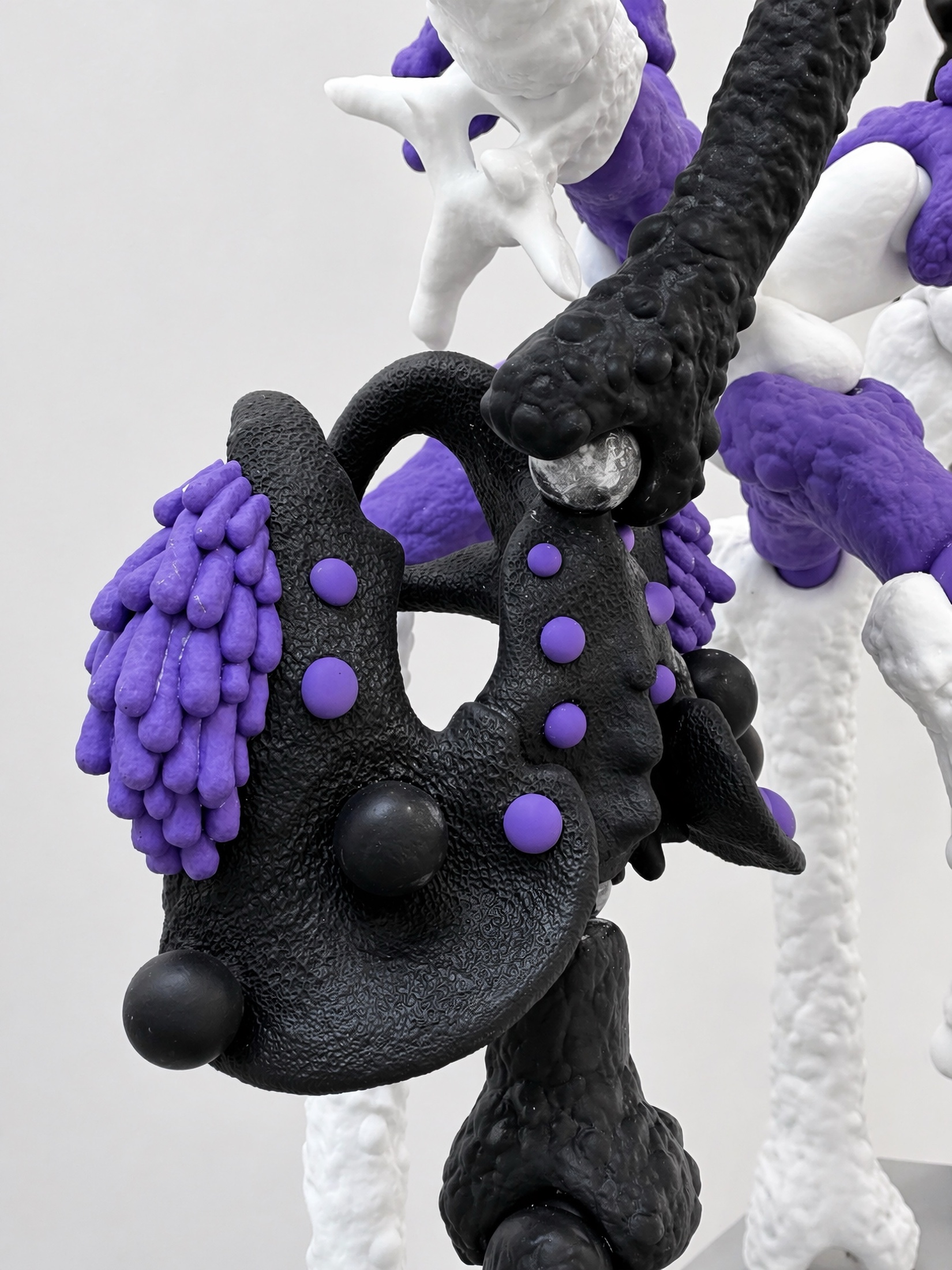 Close view of a black and purple Rebone organizm'os pelvis-like component connected to white bone structures